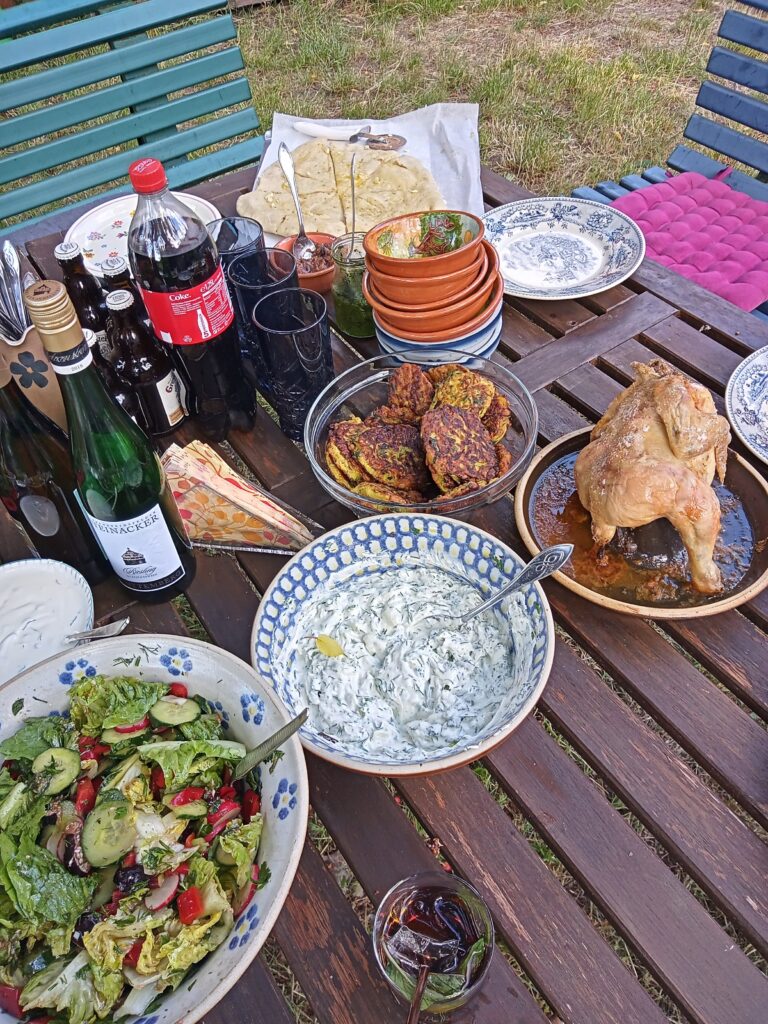 gedeckter Tisch mit Salat, Hähnchen, Schüssel u.a.