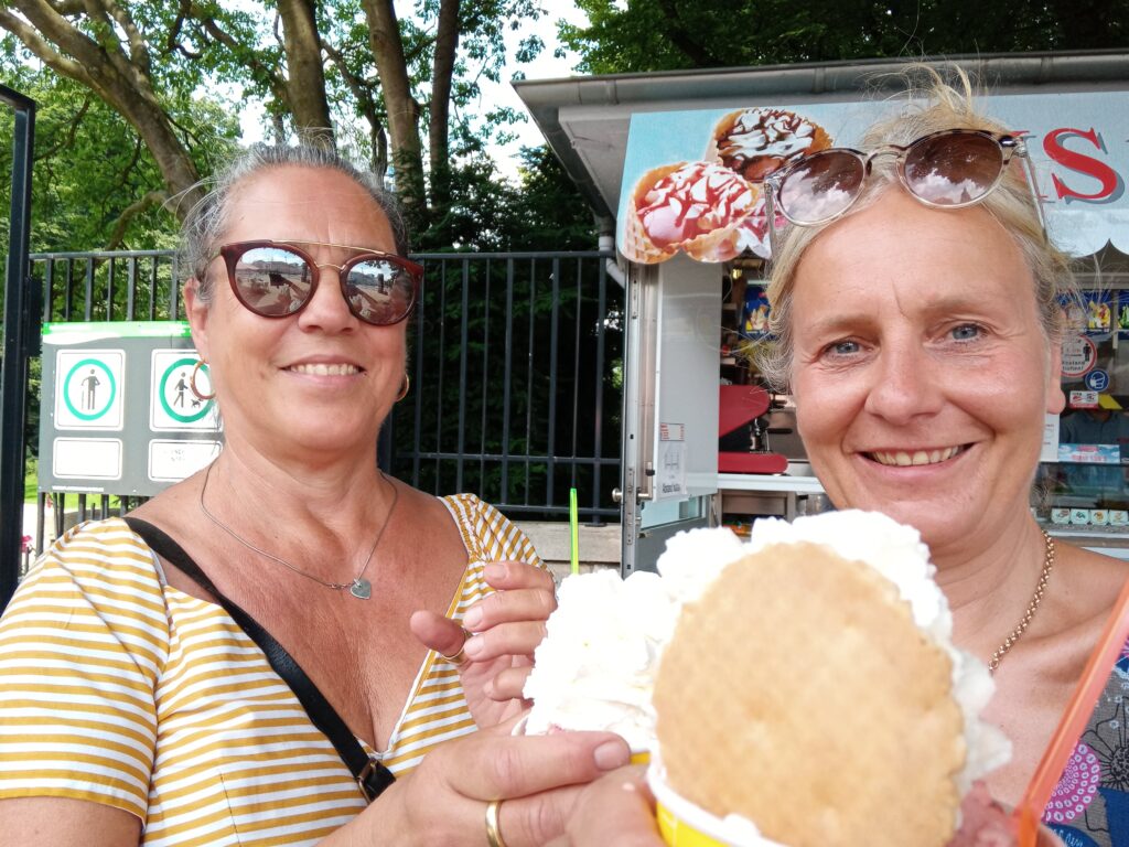 zwei Frauen halten Becher mit Eis und Sahne